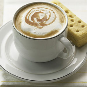 photo of a cup of coffee with a cookie.