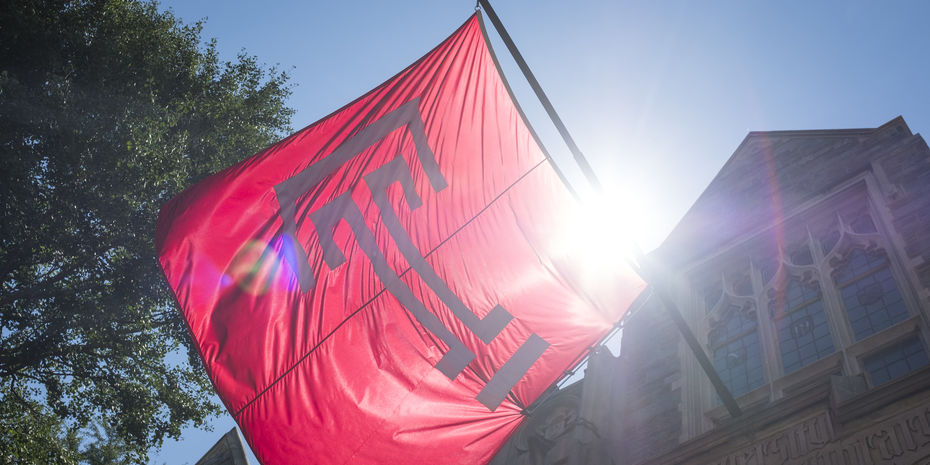 The cherry red Temple T lag waves against a bright sunny and blue sky