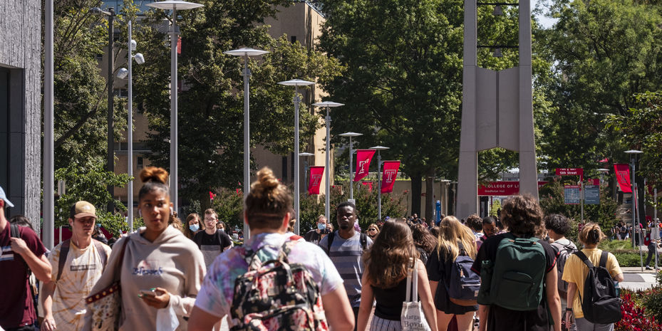 Students walking near the belltower on Main Campus on a sunny spring day