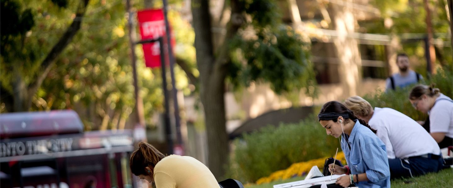 students studying on campus on a spring day