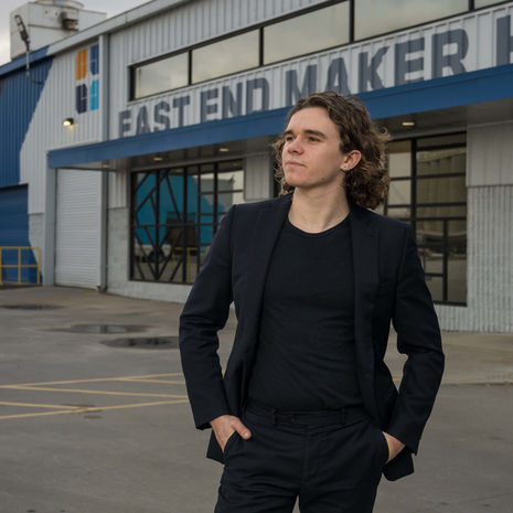 An image of a man, Zimri T. Hinshaw, standing outside a production theater.