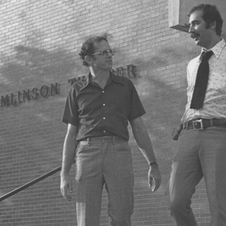 Image of two people walking down the steps of Tomlinson Theater. 