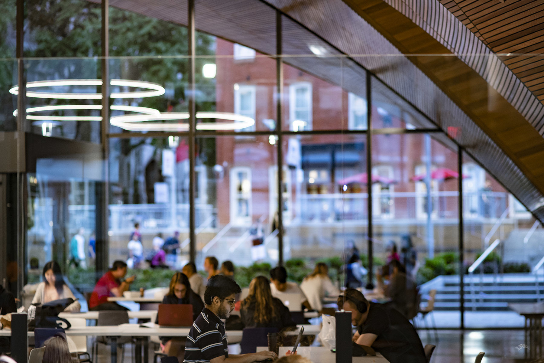 students studying in Charles Library with windows facing out to Liacouras Walk