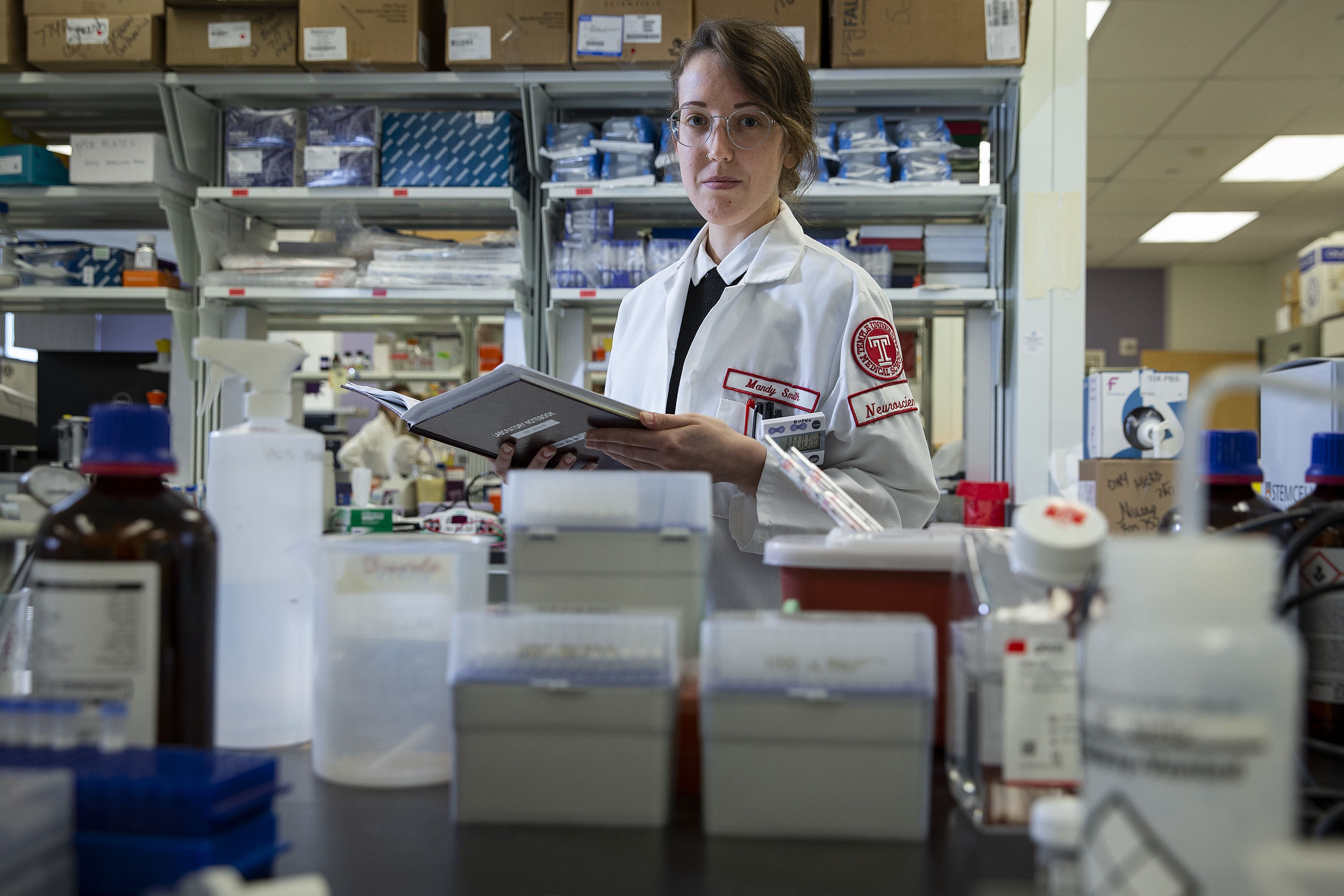 A woman wearing a white school of medicine lab coat
