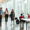 Three College of Liberal Arts students walking together through a student lounge on campus.