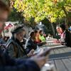 Students talking and sitting outside on campus.