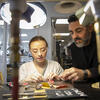 A professor assists a student in the Metals studio.