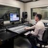 Student working at a computer and large panel in a music tech lab.