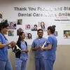 International dental school students conversing in a hallway. 