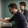 A music professor engages with a student in the classroom