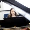 A Boyer College of Music and Dance student plays the piano in a rehearsal room on Temple's campus.