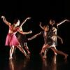 Four dancers perform on stage in a circle.