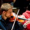 Student plays the violin during rehearsal.
