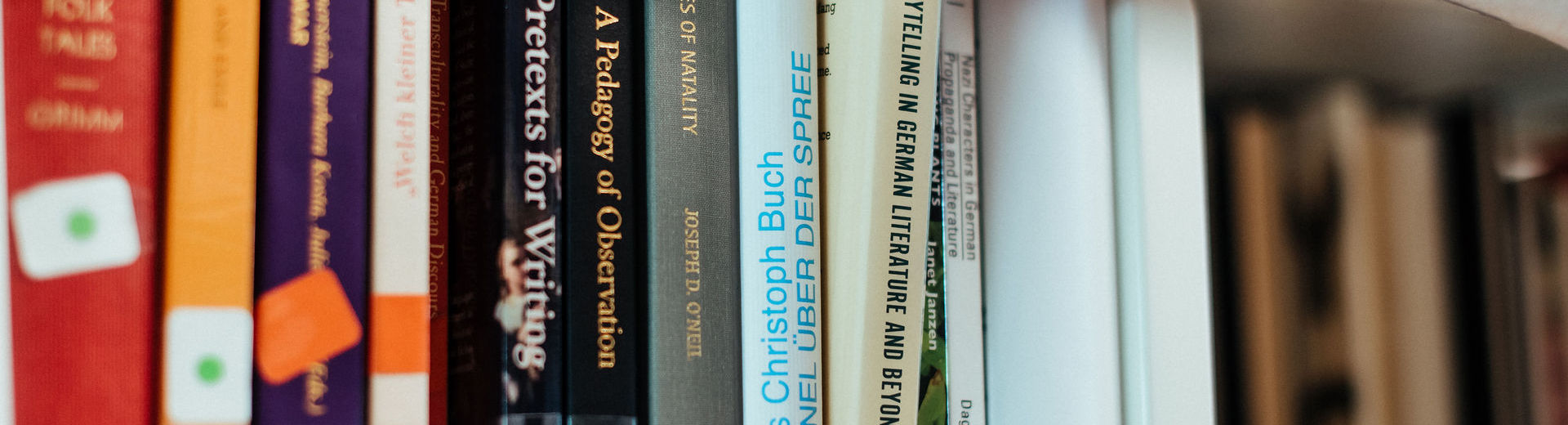 Close up of a hand choosing a book on storytelling on a shelf in the stacks.