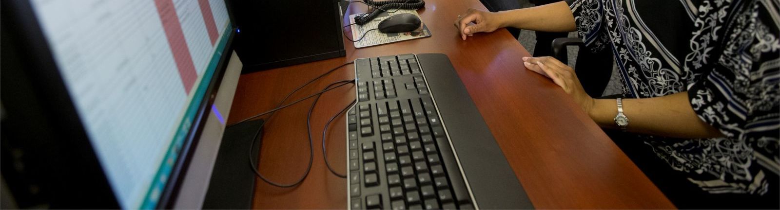 Three women in an office surrounding a computer screen at Temple. 