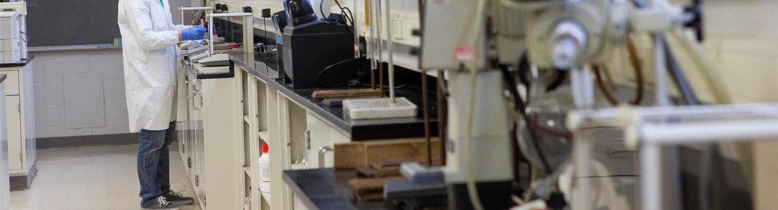 A Temple student measuring out a substance on a scale in a College of Science and Technology lab.