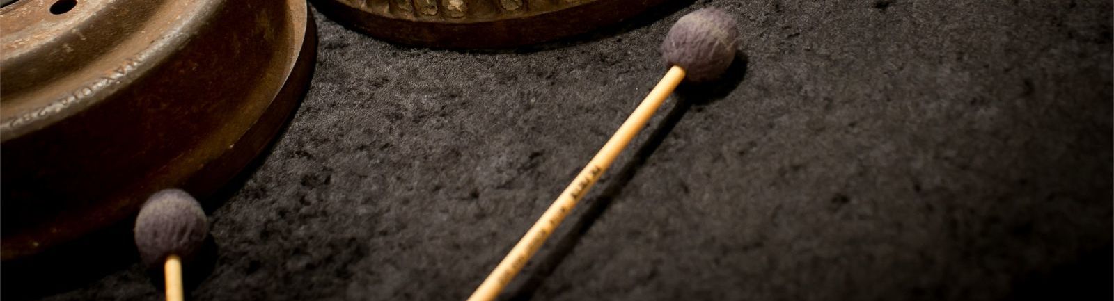 A set of mallets and metal drums.