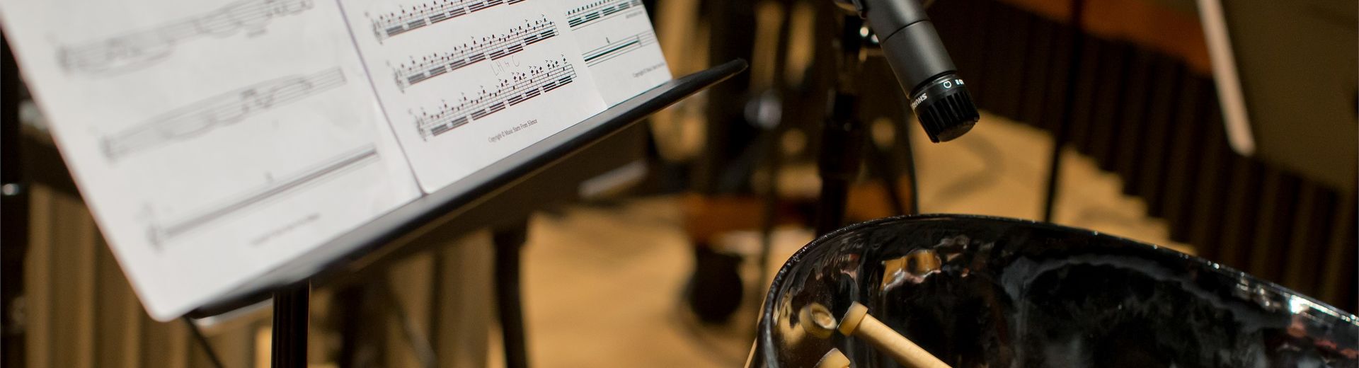 Student playing and recording the drums with sheet music