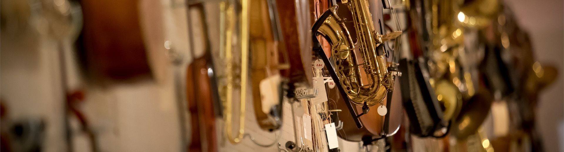 Several string and brass instruments hanging on a wall.