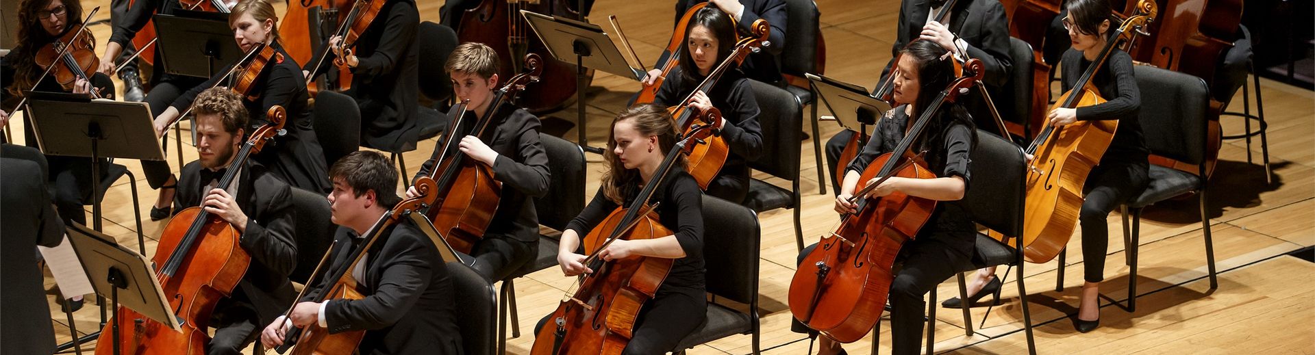 Student orchestra performing on stage.