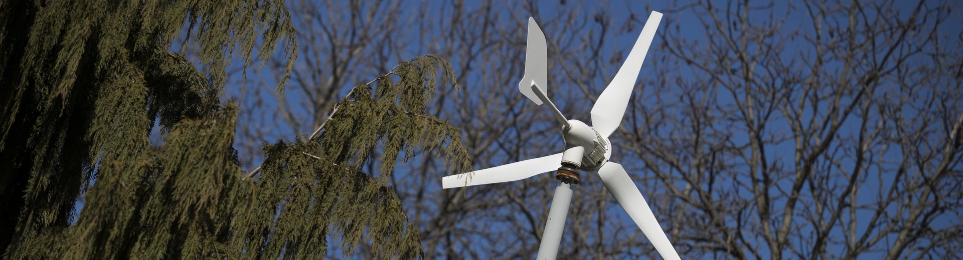 A wind turbine and a sunny, blue sky.