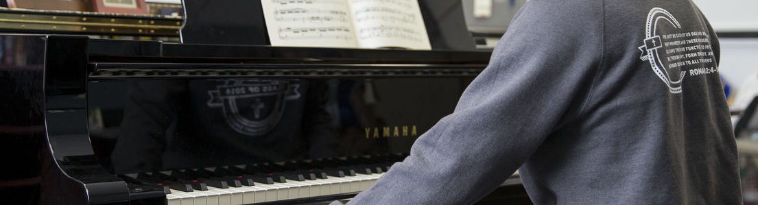 A Temple University student playing a piano.