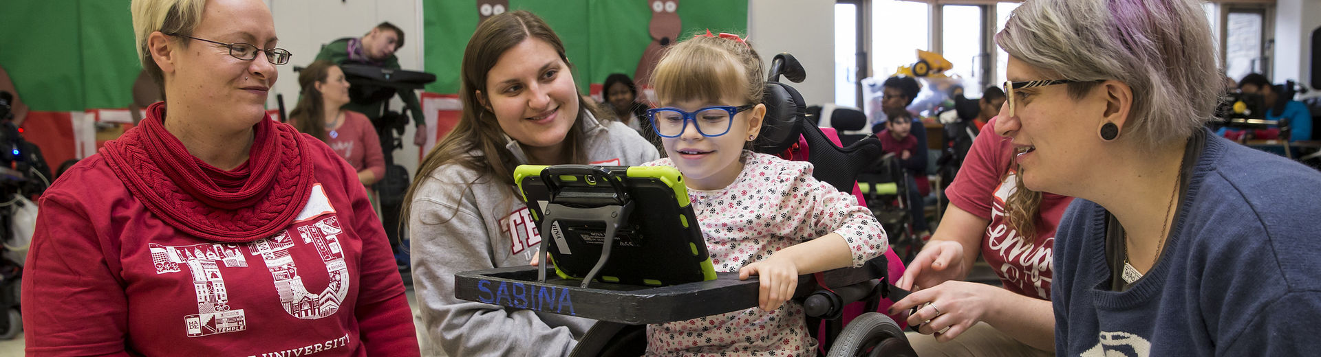 Occupational therapy volunteers gather around a patient.