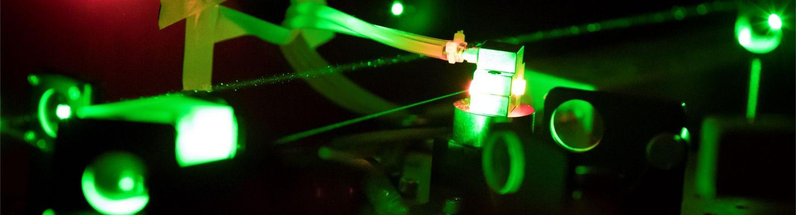 Image of equipment glowing green and red in a College of Science and Technology facility.