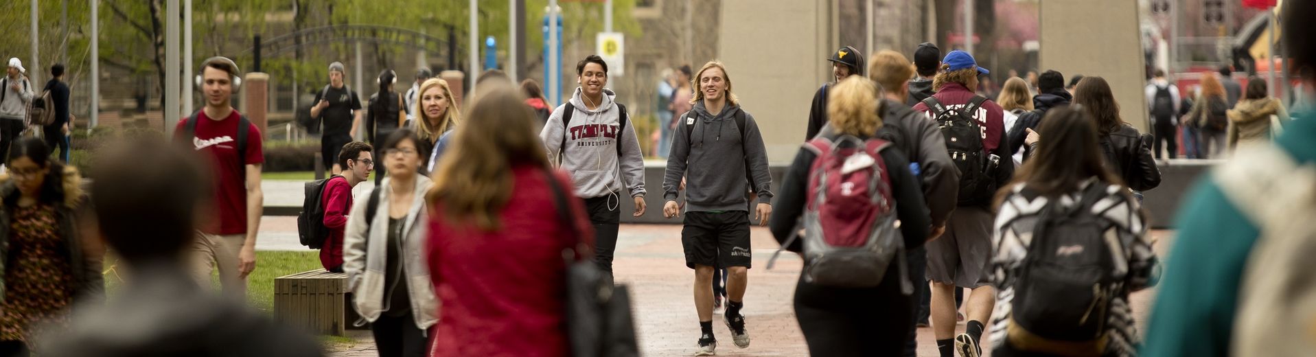 Temple students gathering on Polett Walk in front of the Bell Tower.