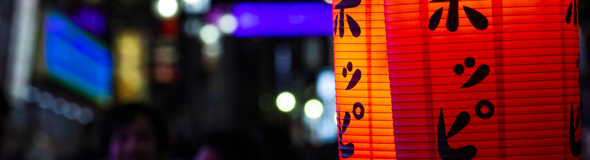 Brightly lit Japanese lanterns in Tokyo at night.