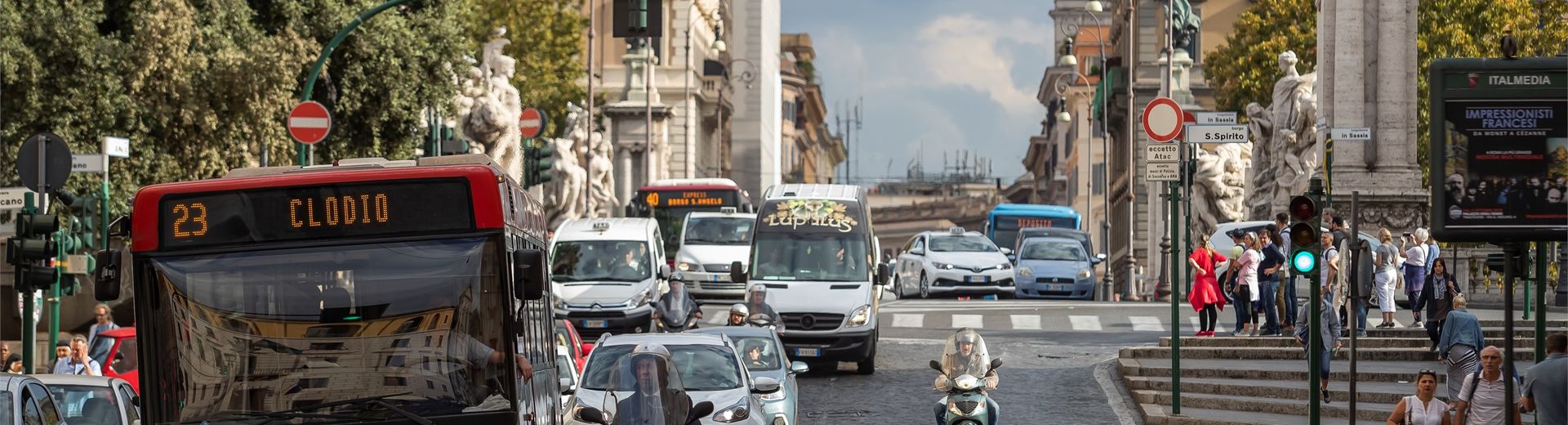 A bus, cars and scooters on a busy street in Rome, Italy.