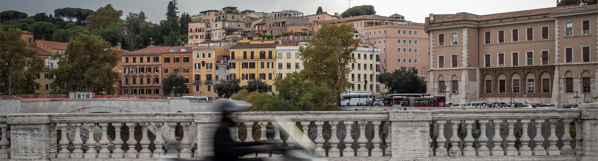 A man riding a scooter through the streets of Rome, Italy.