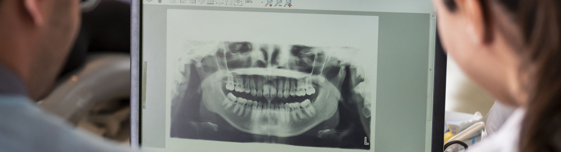 Two dentistry students review an x-ray of teeth and gums.
