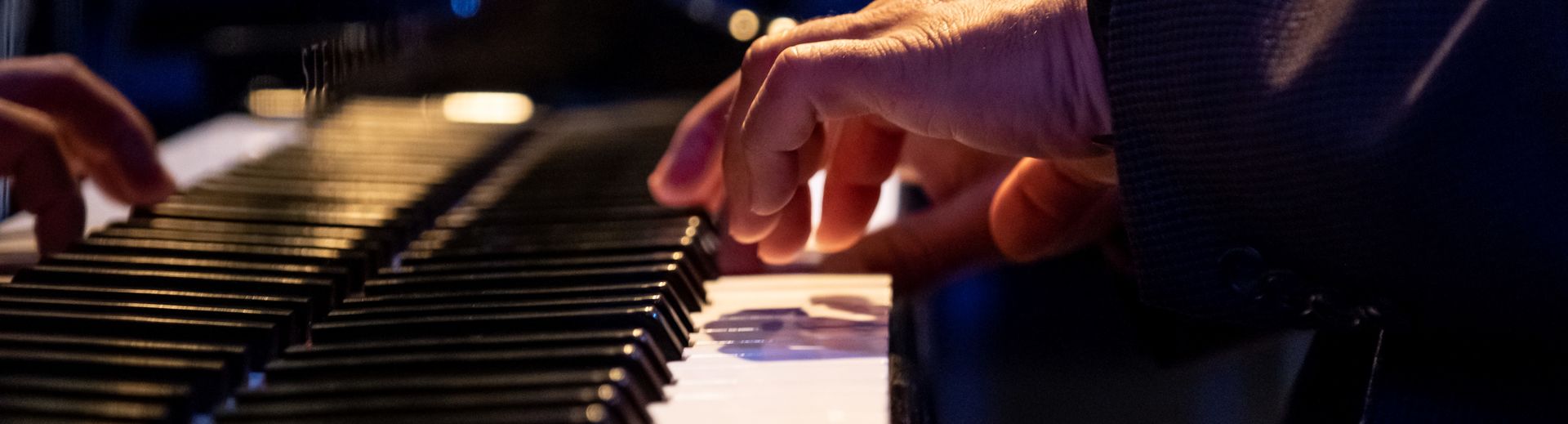 Hands of a pianist on a Steinway grand piano at a performance