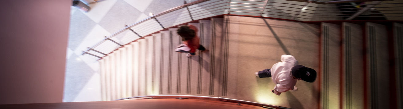 An aerial image of two students walking up and down the stairs. 