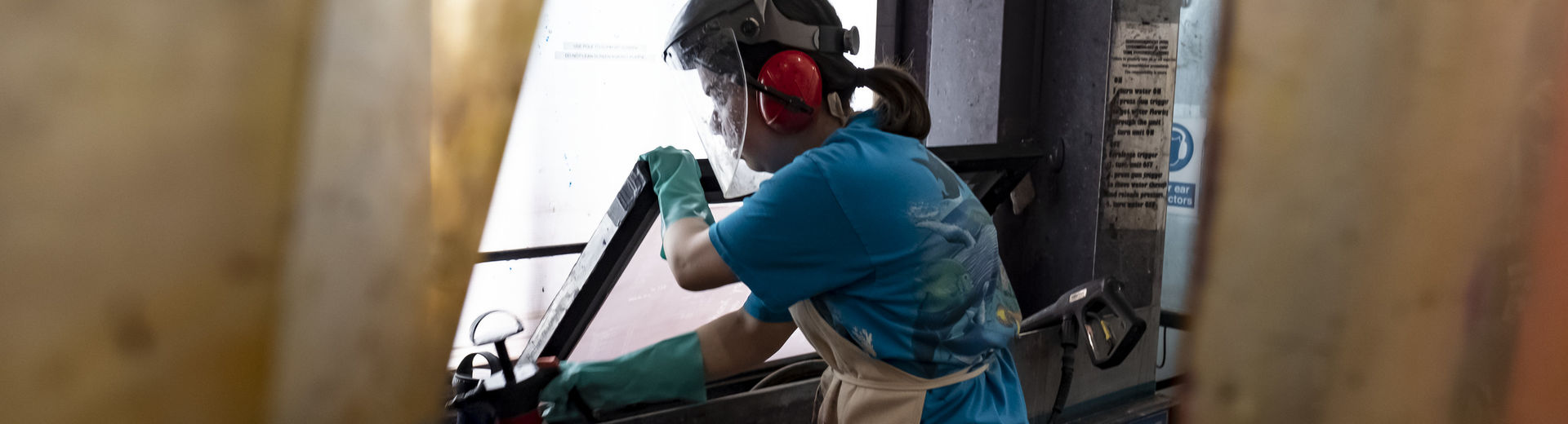 A printmaking student uses a hydrobooth to make a print.