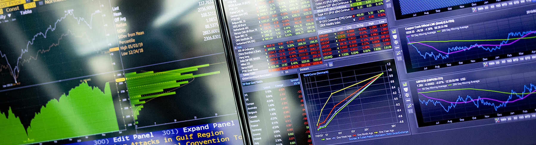 A close-up image of computer screens displaying financial information in graphs and tables