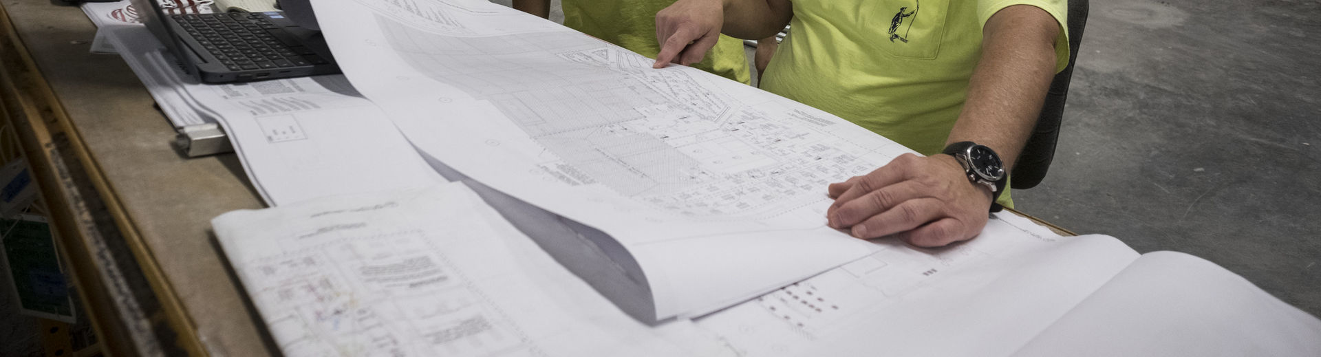 facilities workers reviewing a blueprint of a building. 