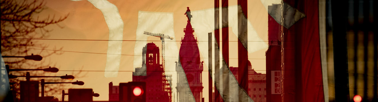 A Temple flag superimposed over an image looking south on Broad Street with City Hall in the center.