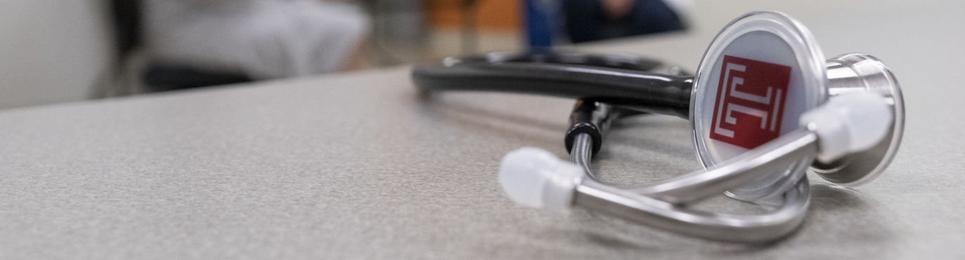 A Temple-branded stethoscope sitting on a table.