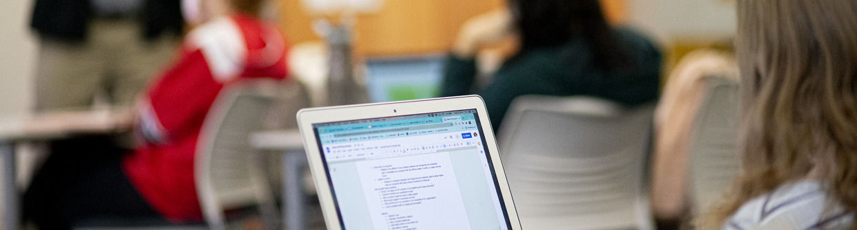 A Klein student taking notes during a class in public relations.