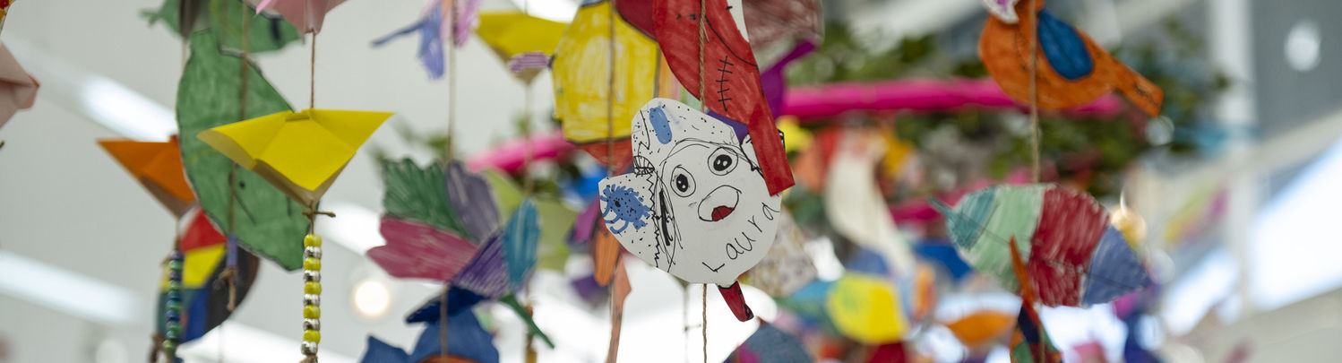 An image of several art projects made by young students hanging from the ceiling