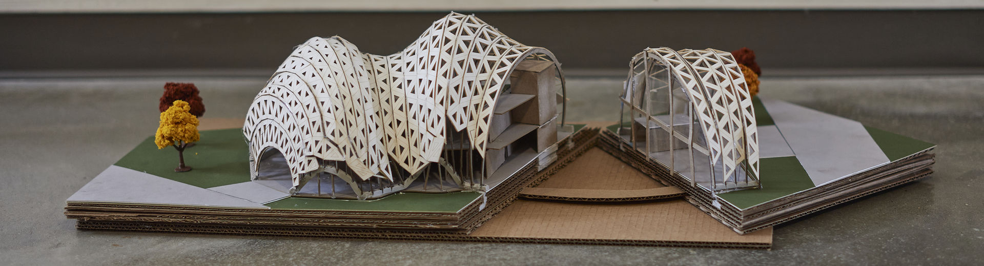 An architectural model of a structure with a curved roof is shown.