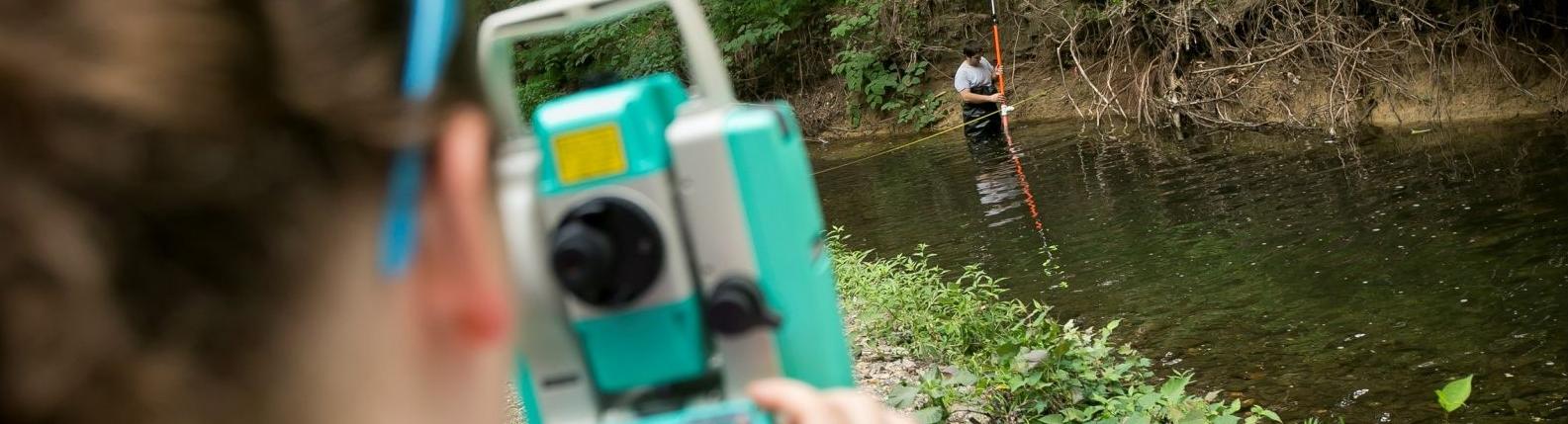 Two Temple students survey a local creek.