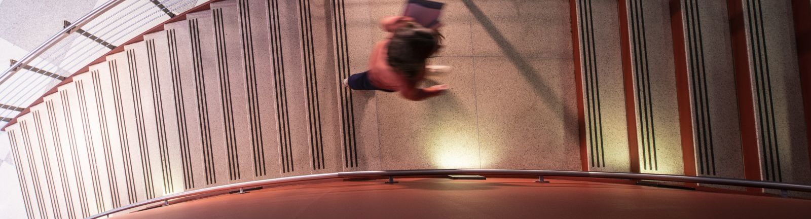 A Temple student mounts the stairs at the Fox School of Business.