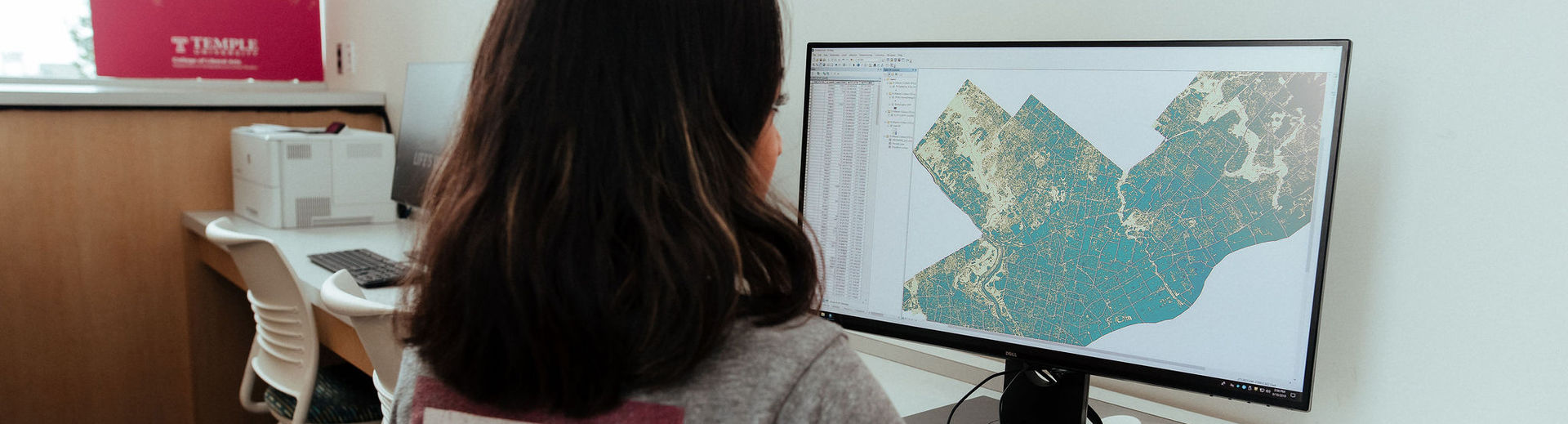 A Temple student studying geographic information systems on a computer.