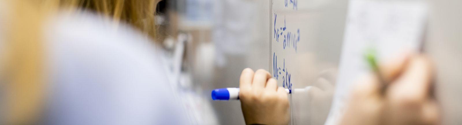 Temple students maps out complex problems on white board