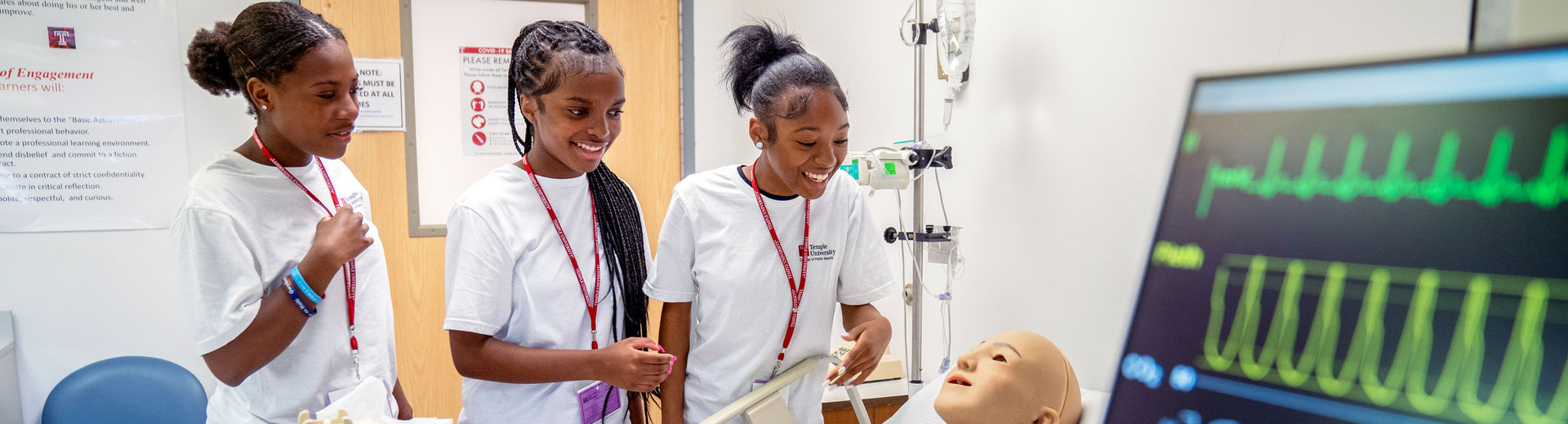 Three Nursing program students working on a simulated patient in the lab