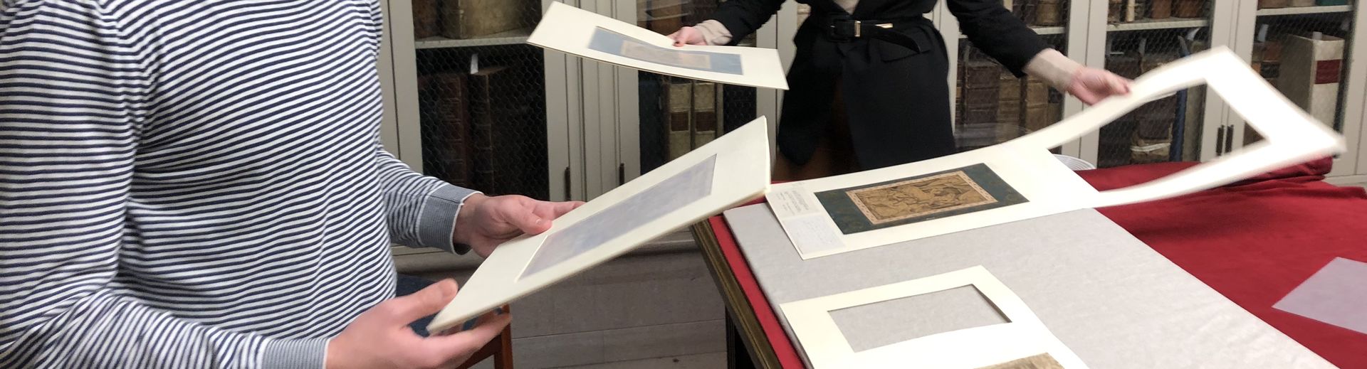 Two students look at images in a library.