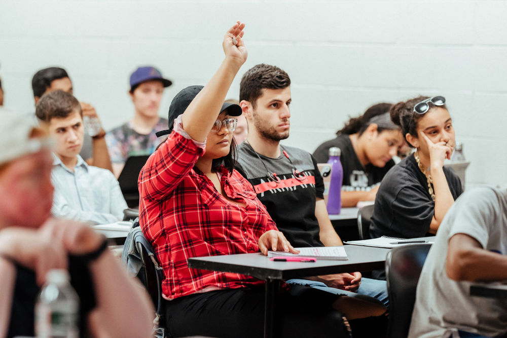 A College of Liberal Arts student raises her hand to ask a question in class.